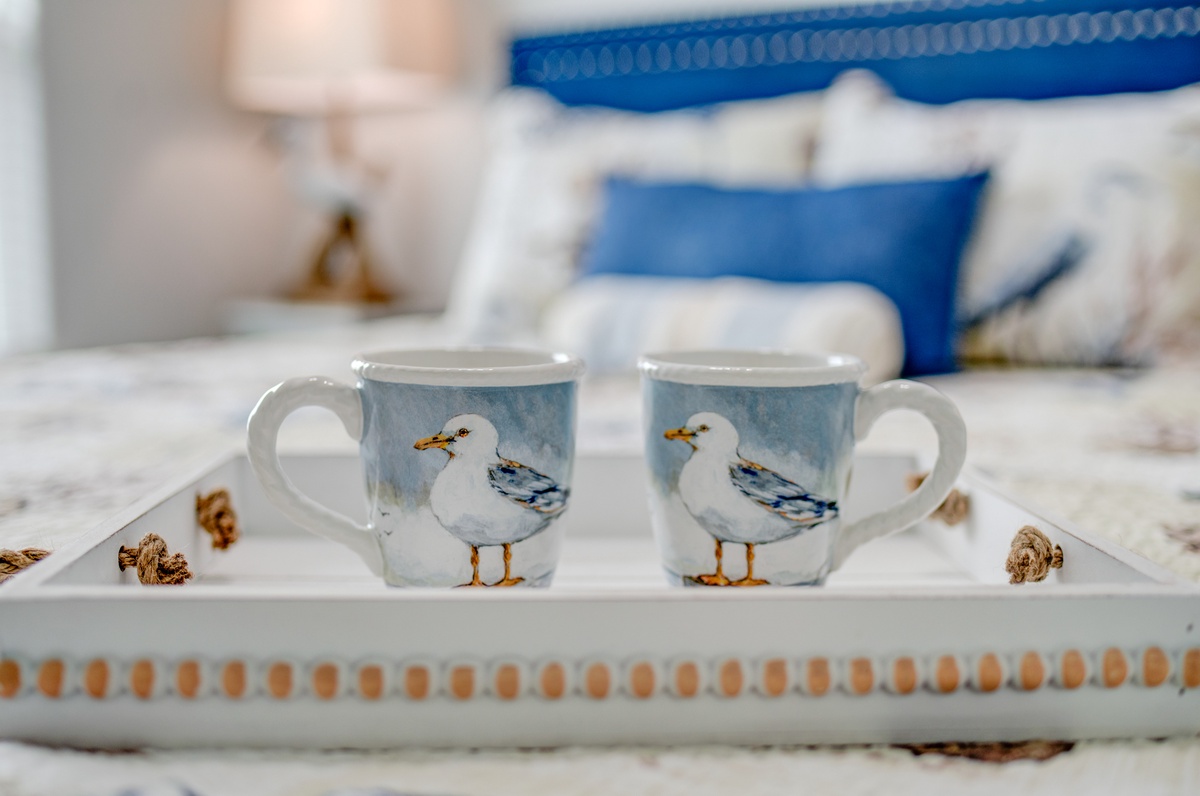 Start your morning with charming seagull mugs on a decorative tray, perfectly placed for your bedside coffee ritual.
