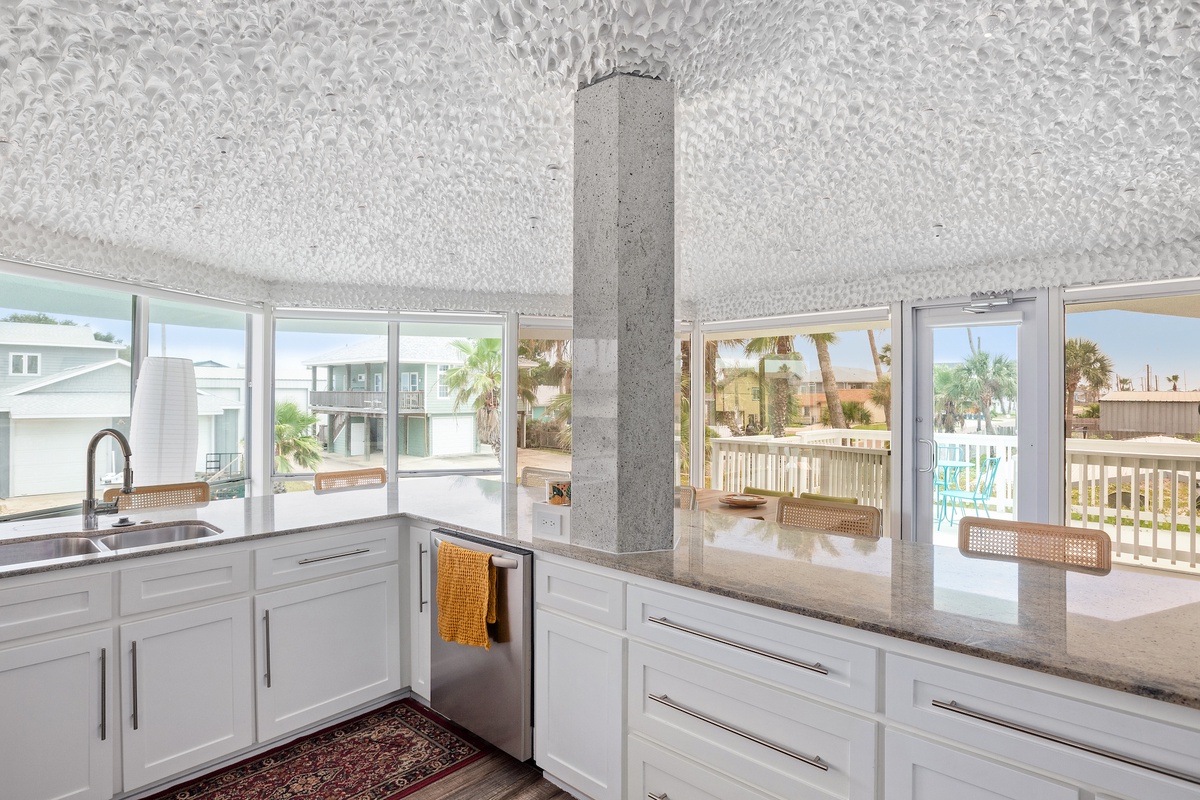 Your modern kitchen opens to stunning tropical views, where cooking becomes a joy with panoramic windows showcasing palm trees and coastal beauty.