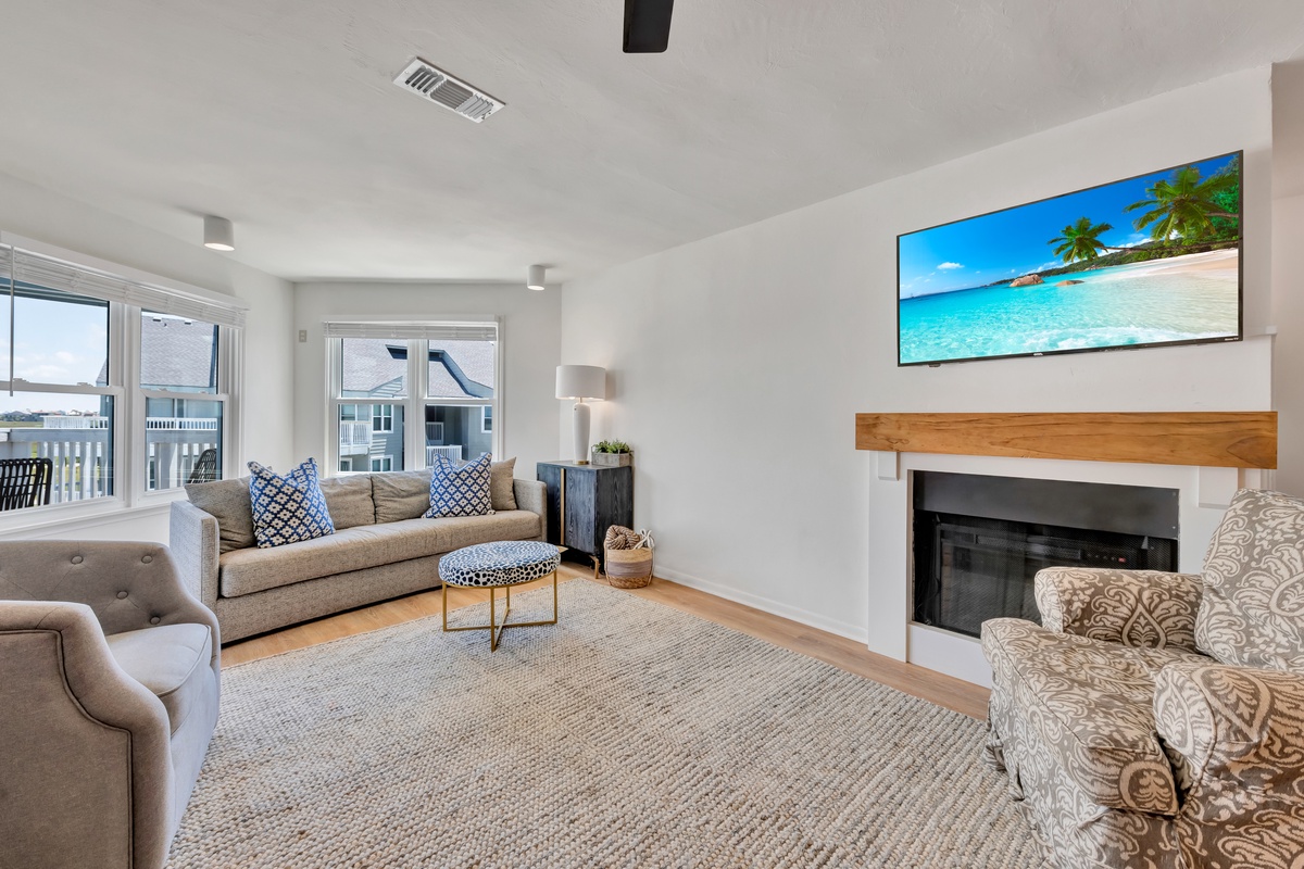Sink into your spacious living room with cozy seating, warm fireplace, and large TV for perfect evening relaxation.