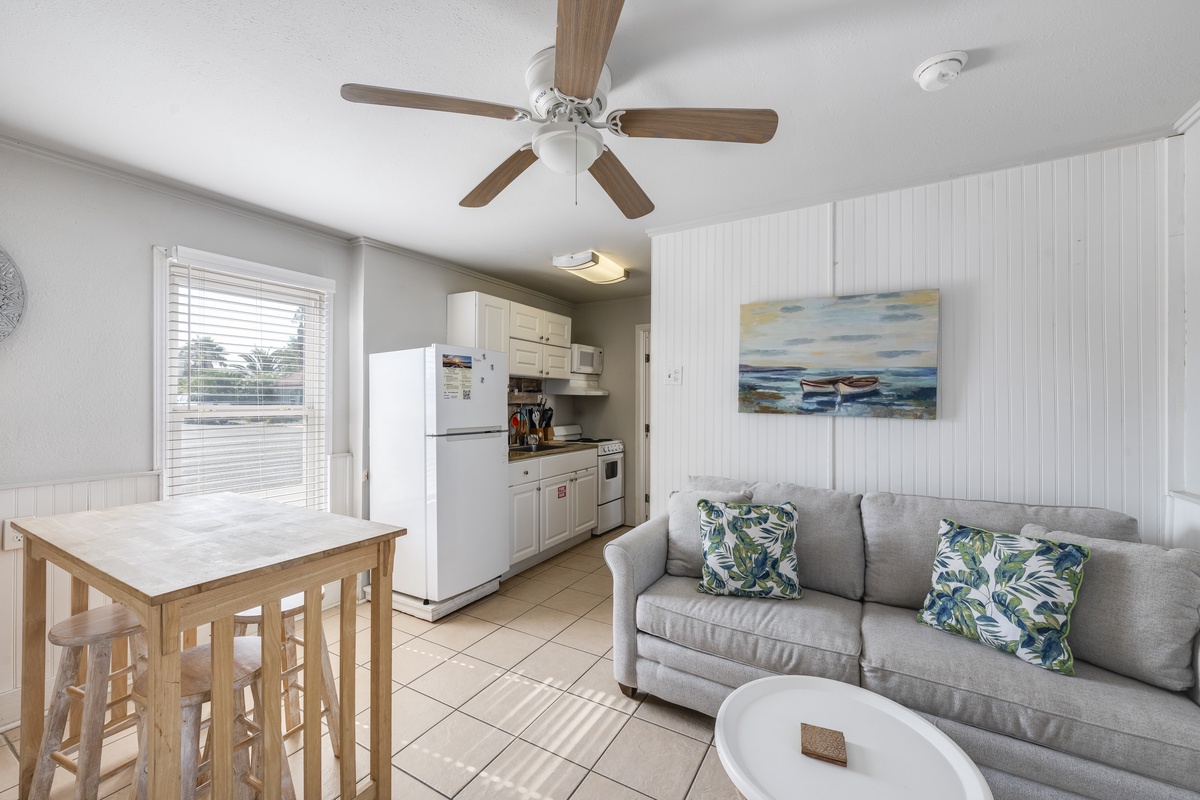Relax in your bright, coastal-themed living space with comfy seating and a full kitchen ready for your vacation meals.