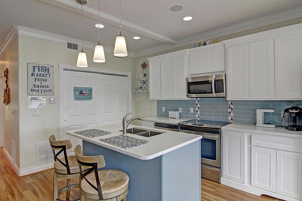Your coastal kitchen awaits with a charming breakfast island, perfect for morning coffee and meal prep in this bright beachside retreat.