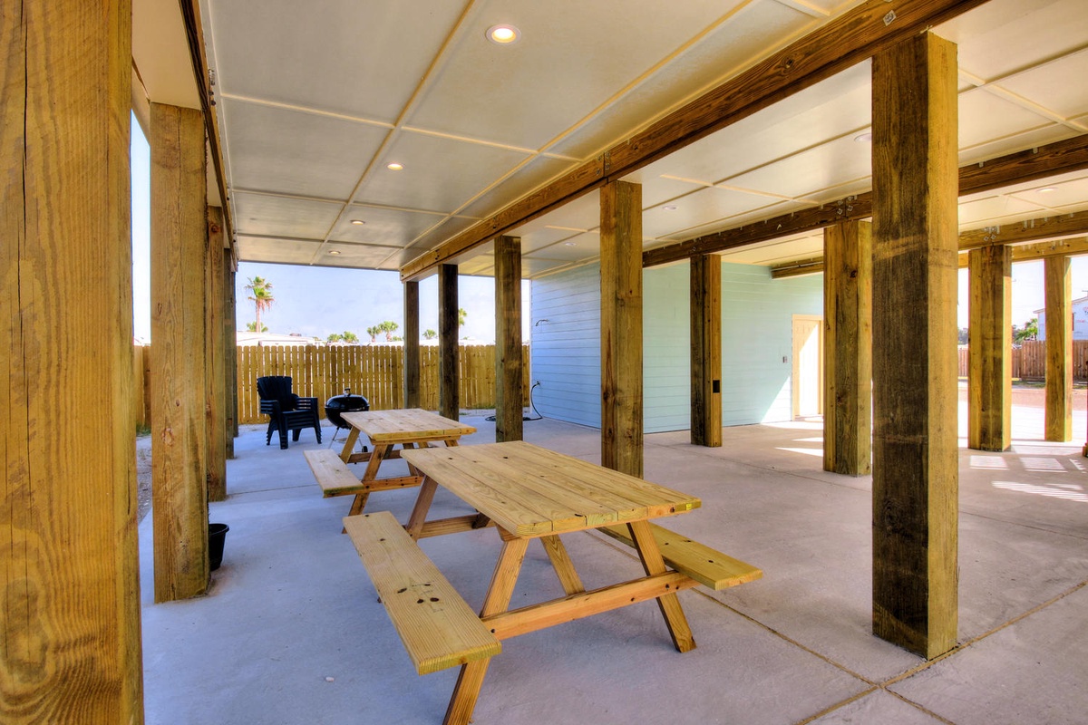 Gather around rustic picnic tables under your private covered pavilion, where wooden beams frame perfect outdoor dining moments.