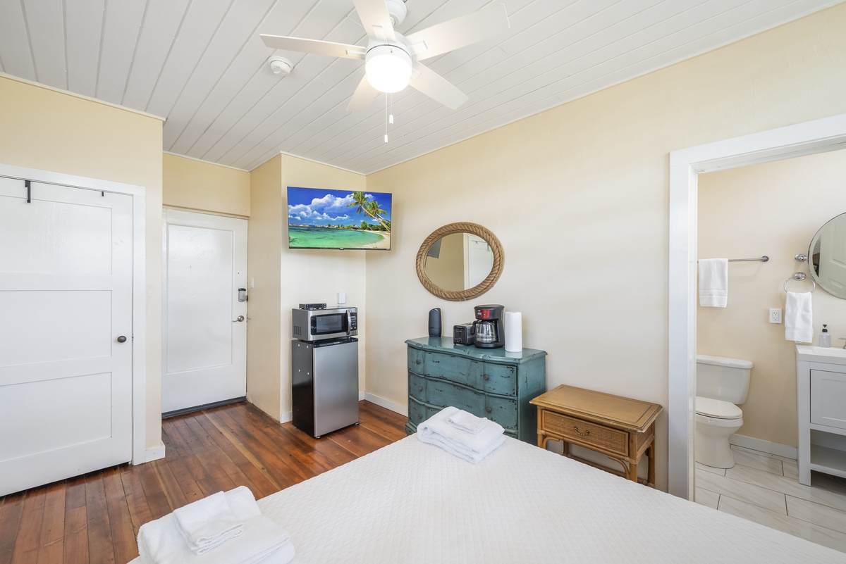Your comfortable bedroom features a ceiling fan, TV, mini-fridge, and microwave for ultimate convenience during your coastal getaway.