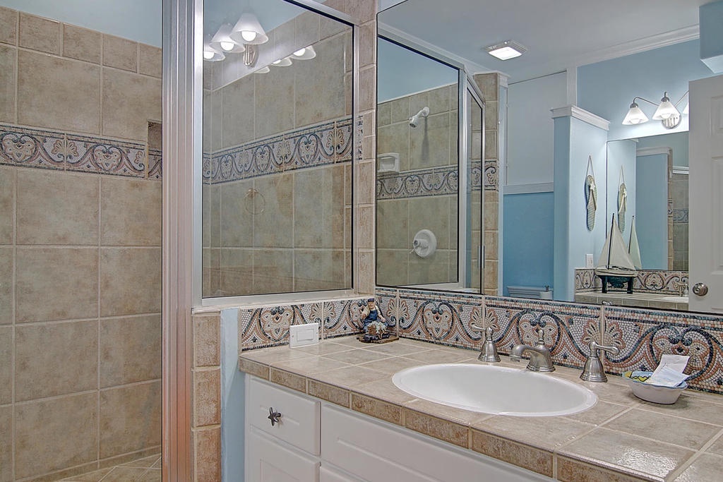 Refresh in your elegant bathroom with beautiful mosaic tile accents, spacious glass shower, and premium fixtures that create a spa-like atmosphere.