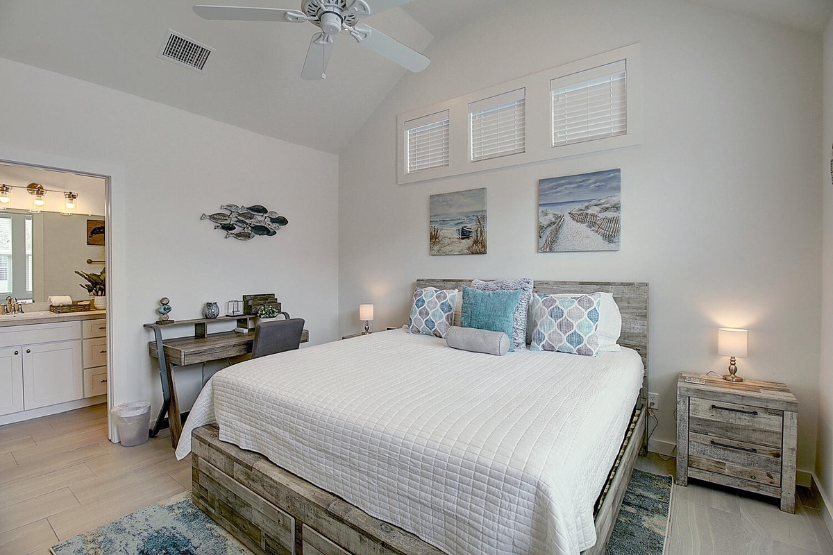 Rest peacefully in your coastal-inspired bedroom with ocean views, comfortable furnishings, and gentle ceiling fan for perfect comfort.