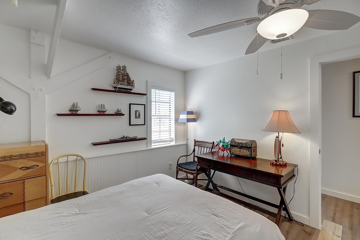 Your nautical-themed bedroom features a comfortable bed, writing desk, and charming ship collections that create a coastal retreat atmosphere.