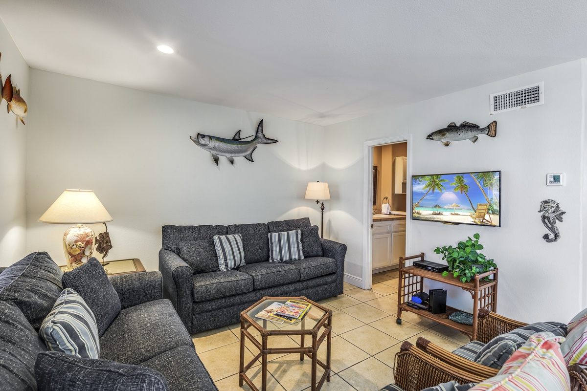 Unwind in your coastal-themed living room, where charming fish art and comfortable seating create the perfect spot for relaxing evenings.