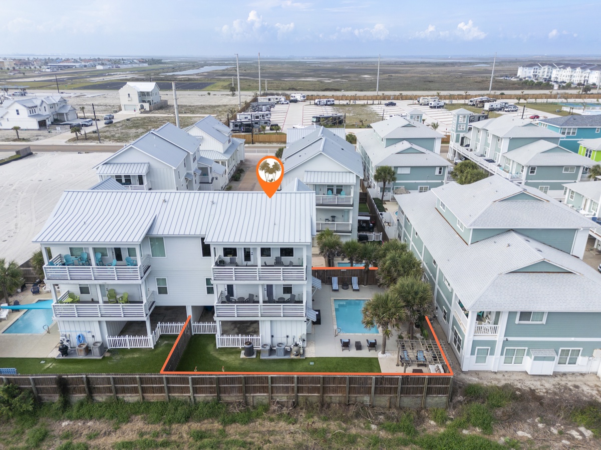 Coastal rental property marked in a beachside community with pools and modern beach houses nearby.