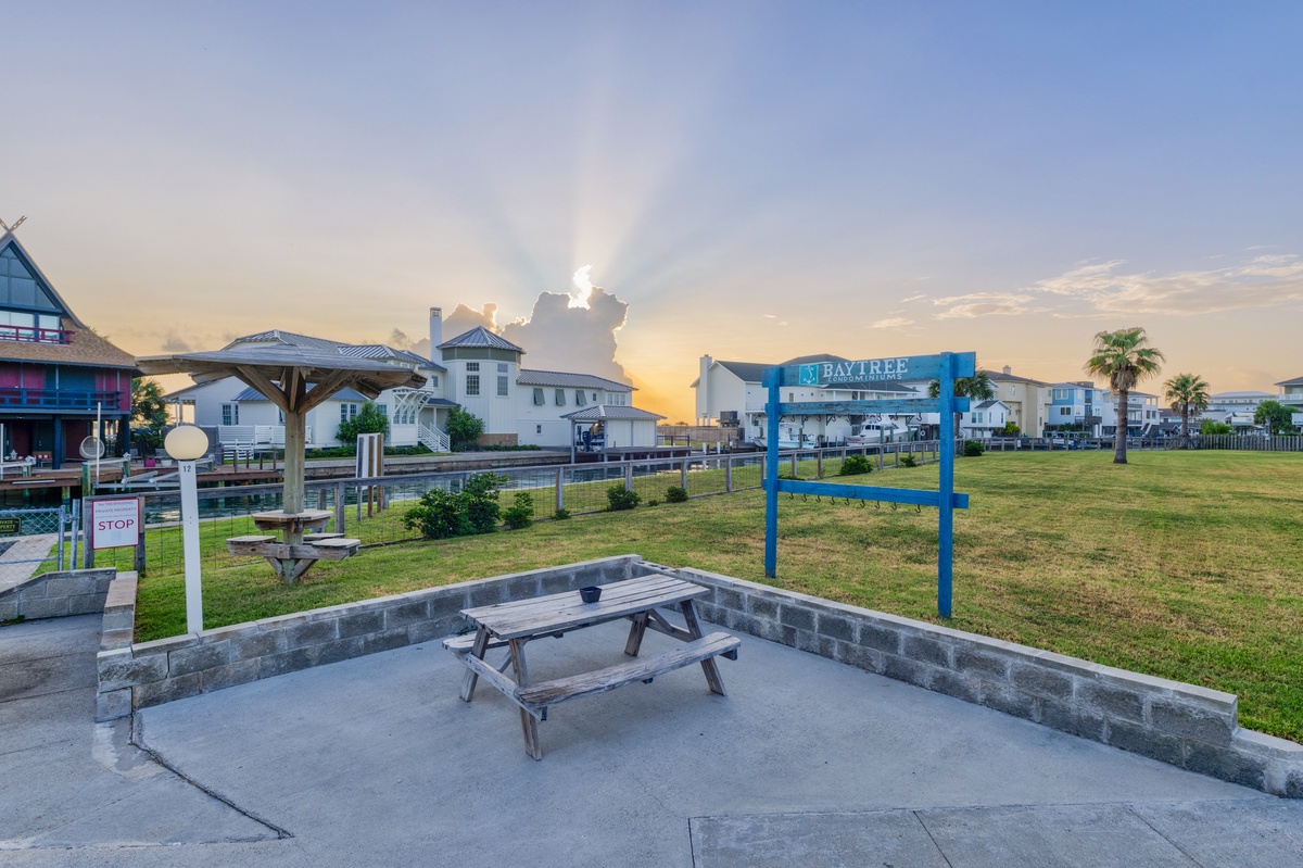 The property sits within a tranquil waterfront resort community featuring waterways, picnic areas, and scenic surroundings at golden hour, perfect for a coastal escape.