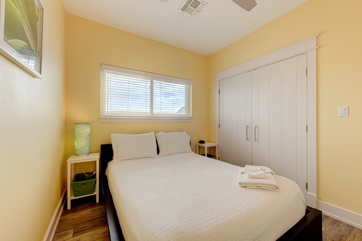 Sink into crisp white linens in your sunny bedroom, where warm yellow walls create a cheerful retreat after exploring the area.