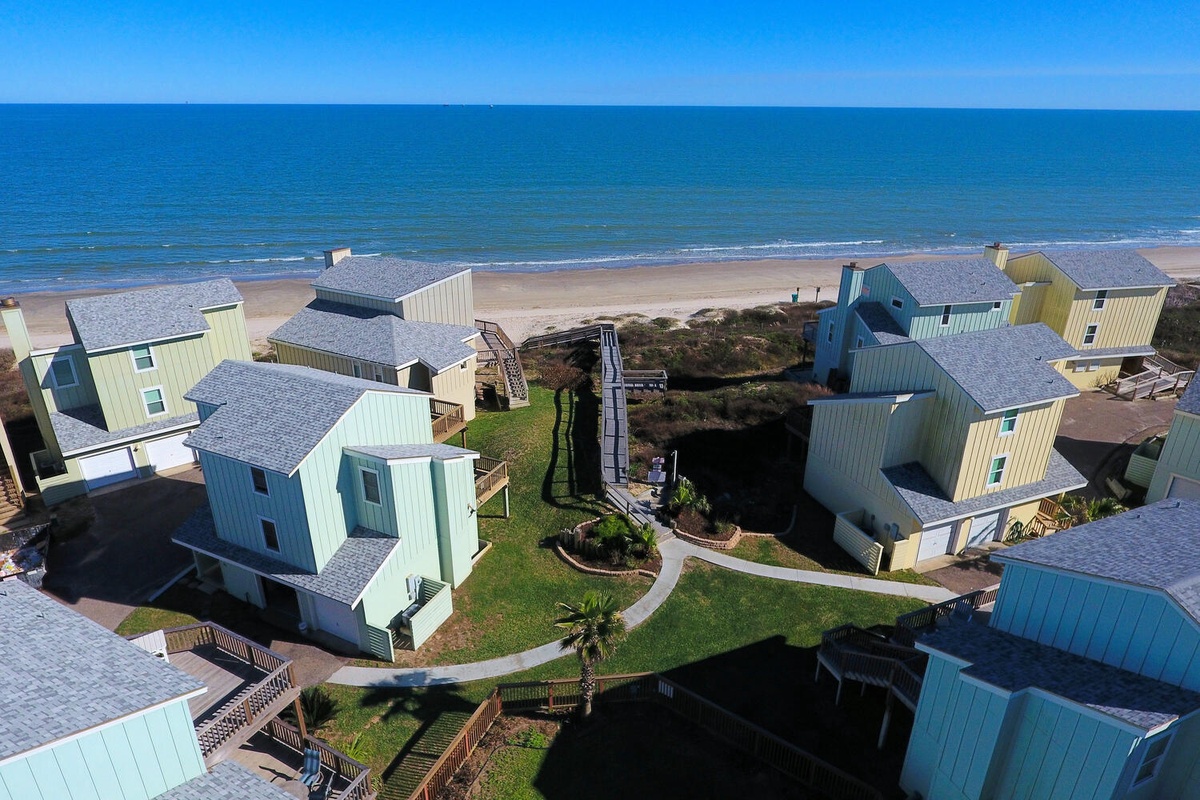 Colorful beachfront vacation homes nestled in a coastal community with direct beach access and scenic ocean views.