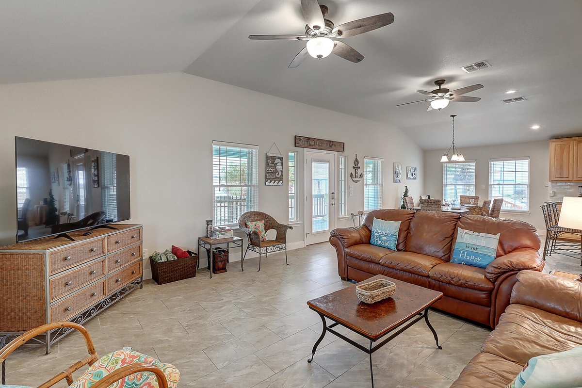 Unwind in your spacious living area with plush leather seating, large TV, and coastal decor touches that create the perfect home away from home.