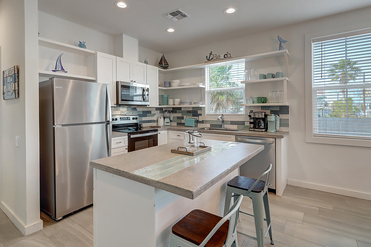 Your fully equipped kitchen invites culinary adventures with stainless appliances, granite counters, and coastal charm.