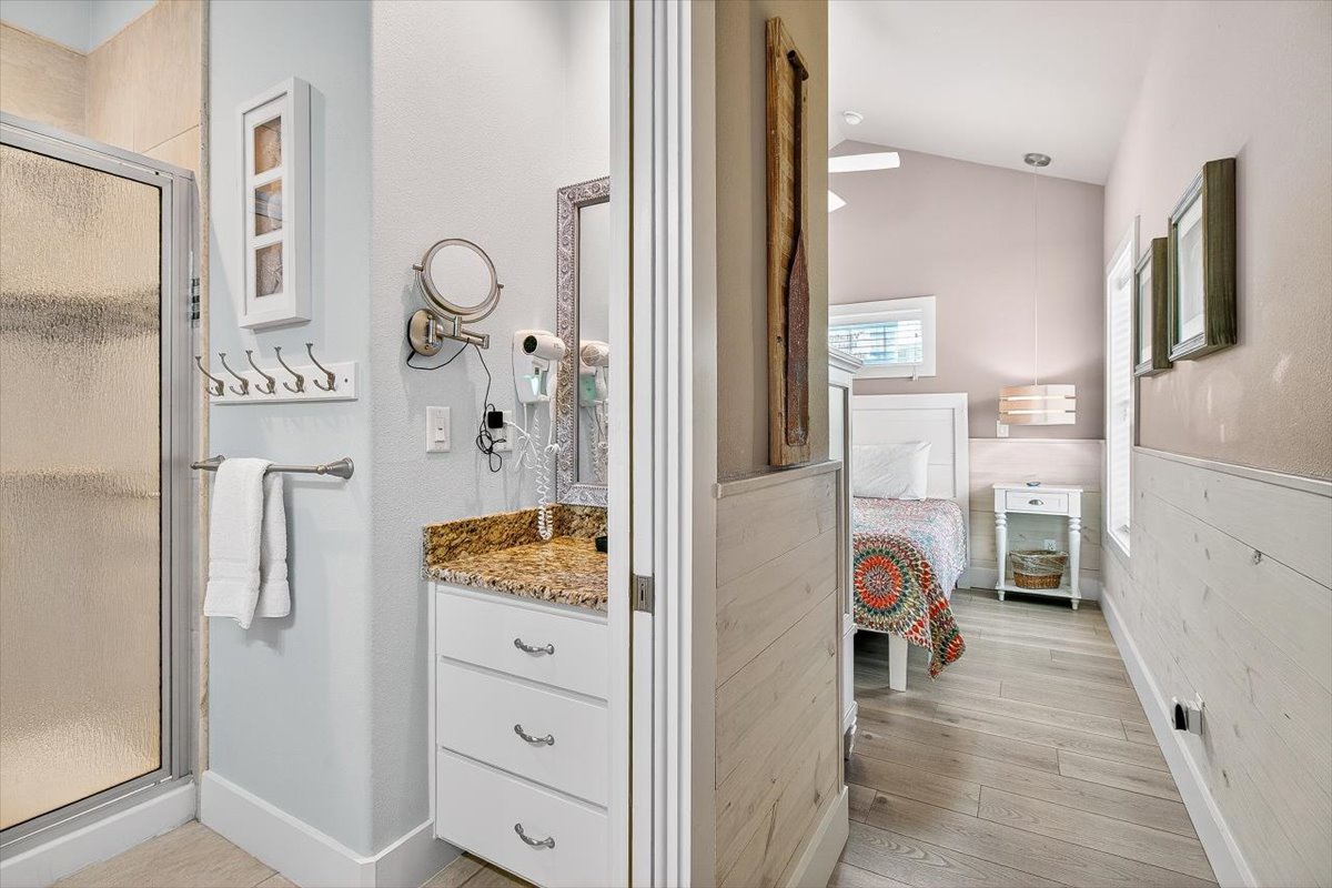 Your private bathroom features a spacious walk-in shower and granite vanity, with thoughtful storage and elegant coastal touches throughout.