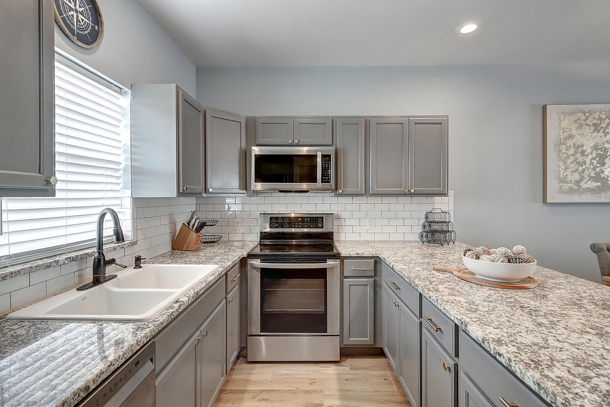 Your sleek kitchen features granite counters, stainless steel appliances, and subway tile backsplash—perfect for preparing memorable meals during your stay.