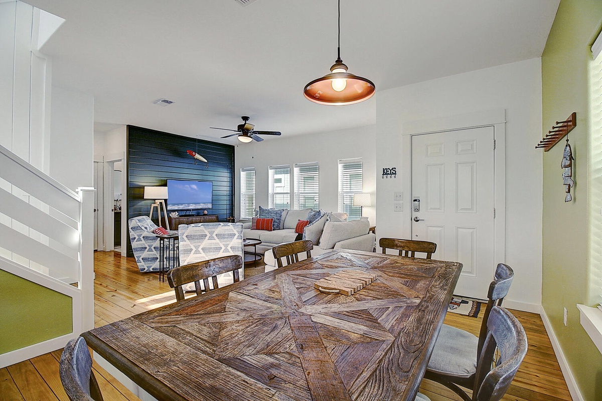 Your open-concept living space flows beautifully from dining to lounge, with coastal touches and warm wood accents creating the perfect gathering spot.