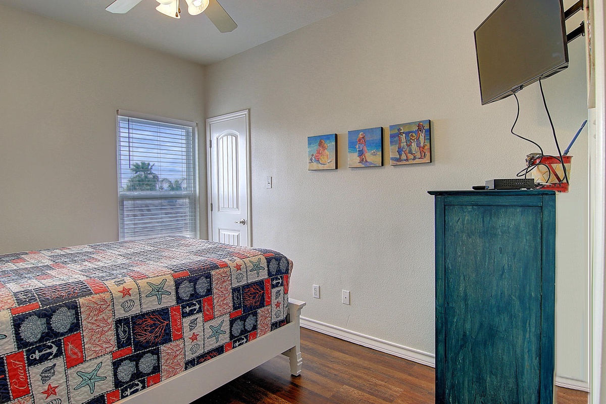 Your kids will love this cheerful bedroom with pirate-themed bedding, colorful artwork, and entertainment setup for cozy movie nights.