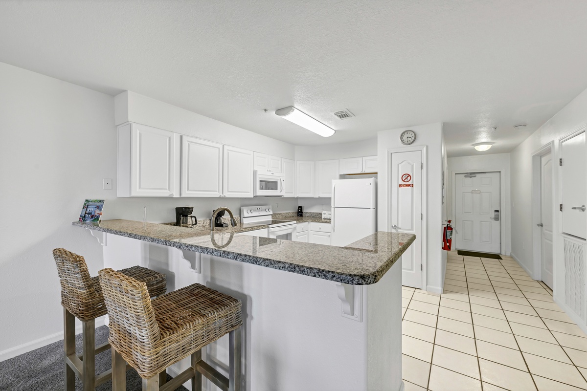 Your fully equipped kitchen features granite countertops and a breakfast bar where you can enjoy morning coffee while planning your day.