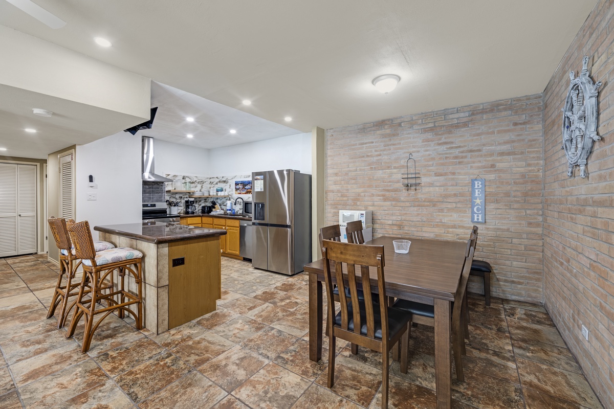 Cook your favorite meals in this fully equipped kitchen, then gather around the dining table for quality time. The coastal decor and open layout create a relaxed, beachy vibe for your stay.