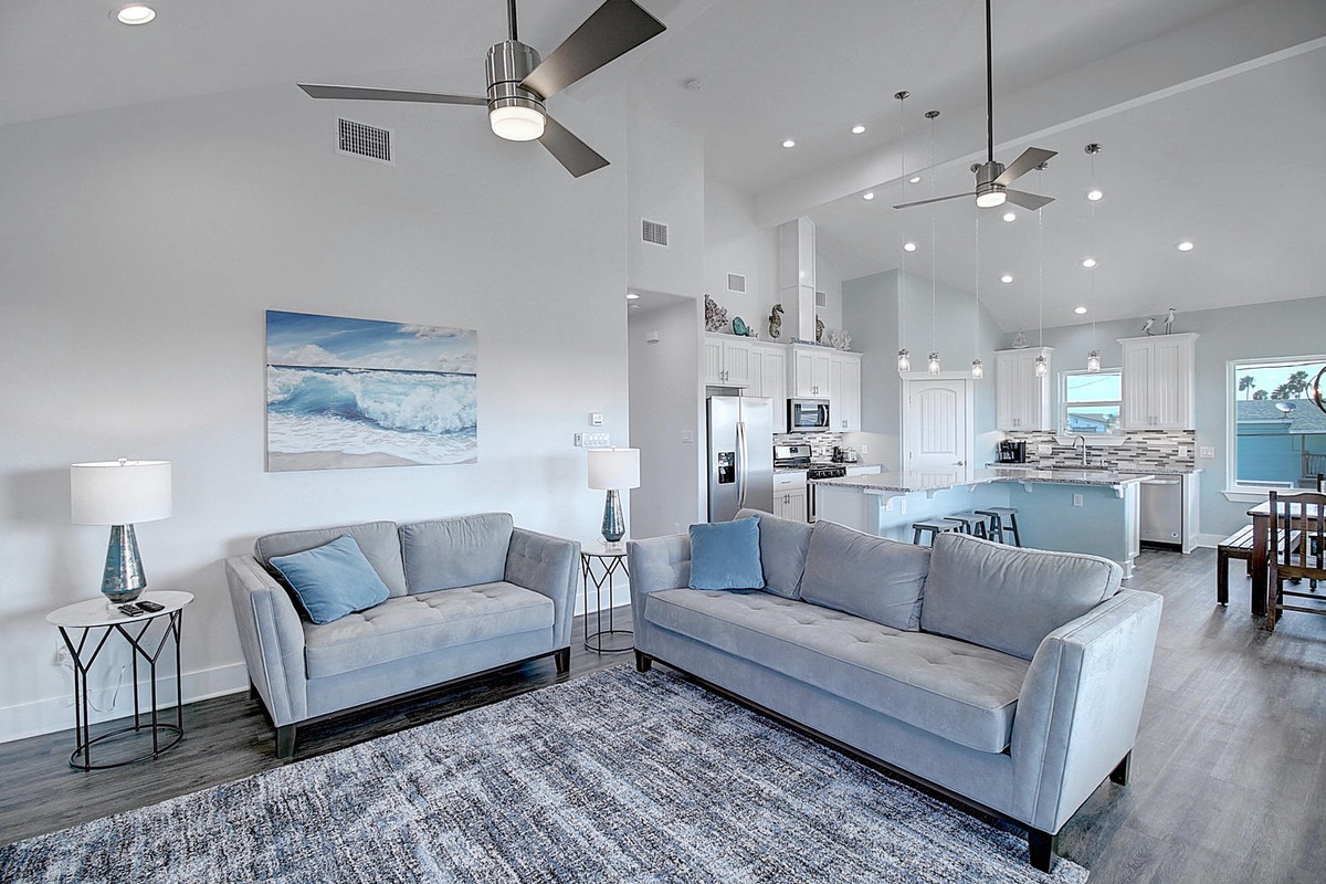 Relax in your bright, airy living space featuring plush sectional seating and modern coastal décor that flows seamlessly into your fully-equipped kitchen.