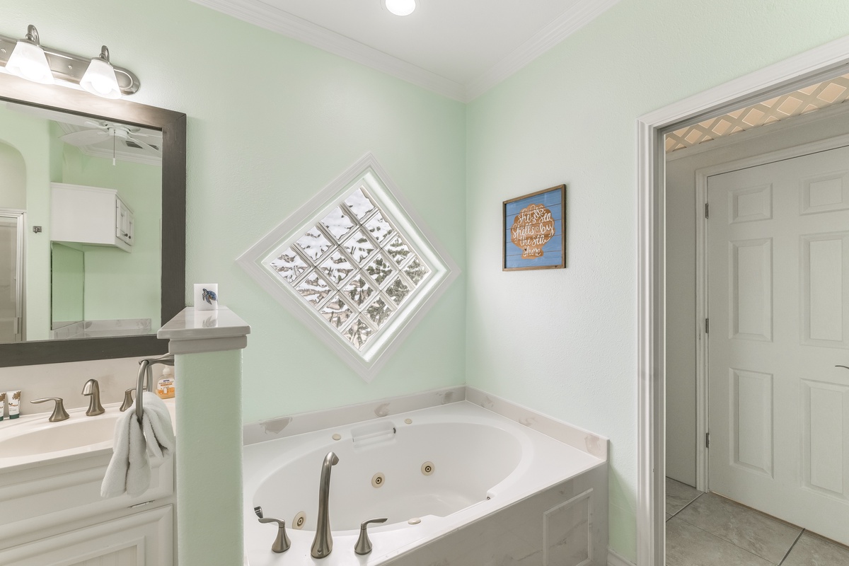 Slip into your own private spa sanctuary with a luxurious jetted tub surrounded by soothing mint walls and charming coastal decor.