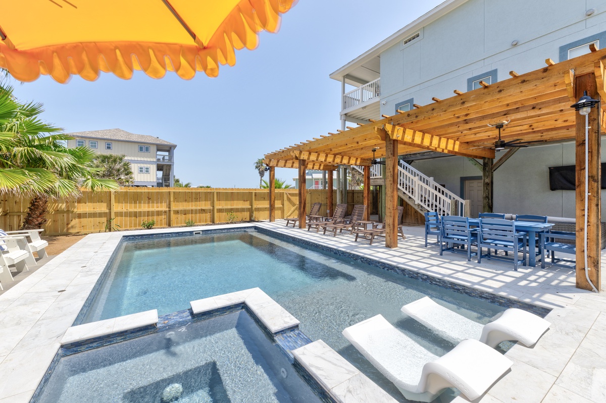 Your private pool oasis features built-in seating and a spa for ultimate relaxation under the covered pergola.