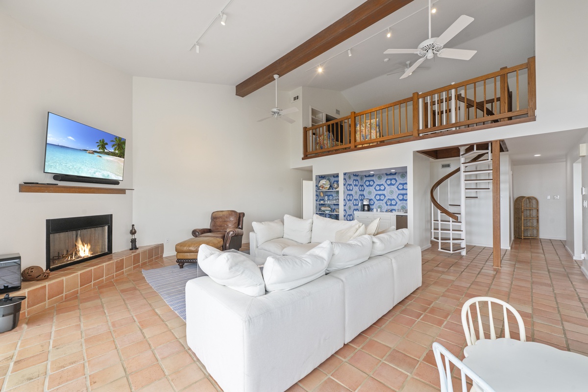 Sink into plush sofas beside the warm fireplace, where soaring ceilings and rustic beams create your perfect retreat sanctuary.