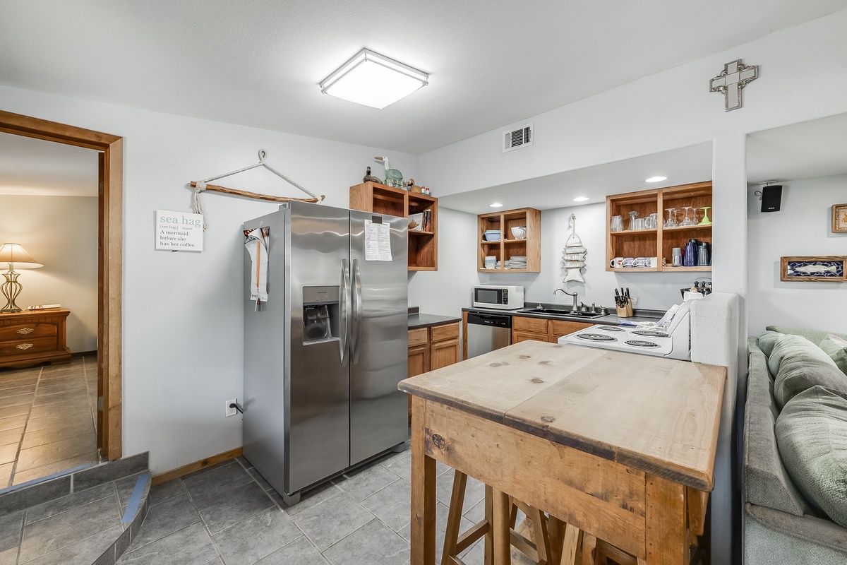 Your fully-equipped kitchen features warm wood cabinets, stainless appliances, and a rustic island perfect for meal prep and casual dining.