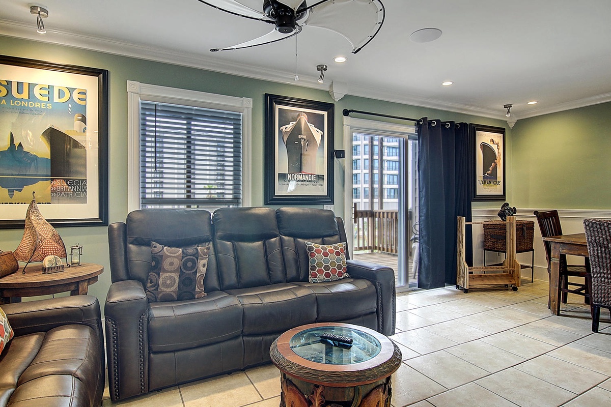 Settle into your comfortable leather sofa where vintage posters and coastal charm create the perfect atmosphere for your seaside getaway.