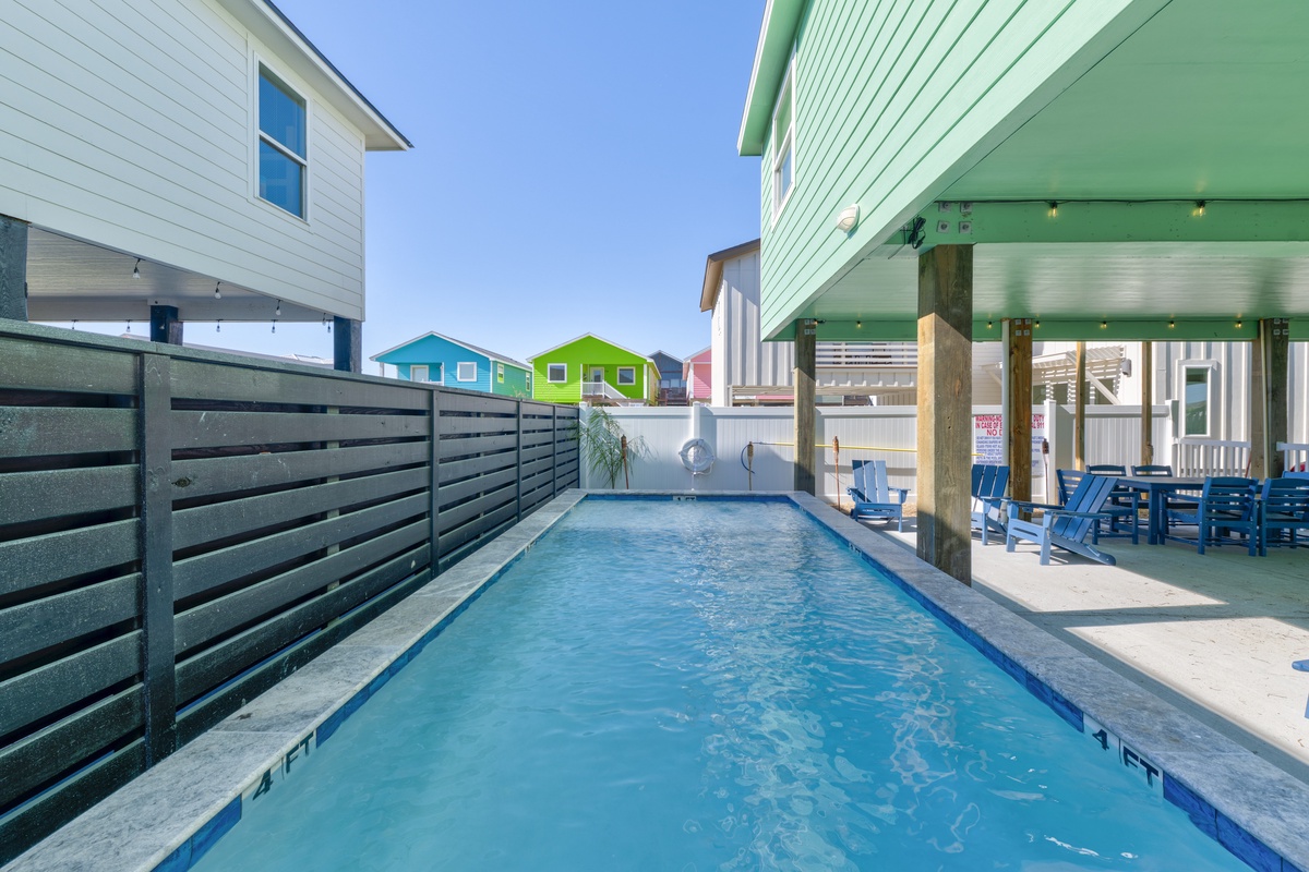 Dive into your private pool oasis, surrounded by colorful beach houses and shaded dining under the covered patio.