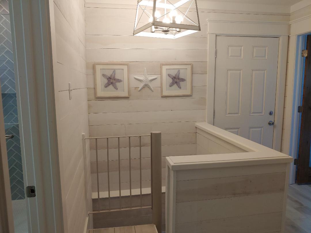 Charming coastal-themed stairway with starfish artwork welcomes you to your upper level retreat.