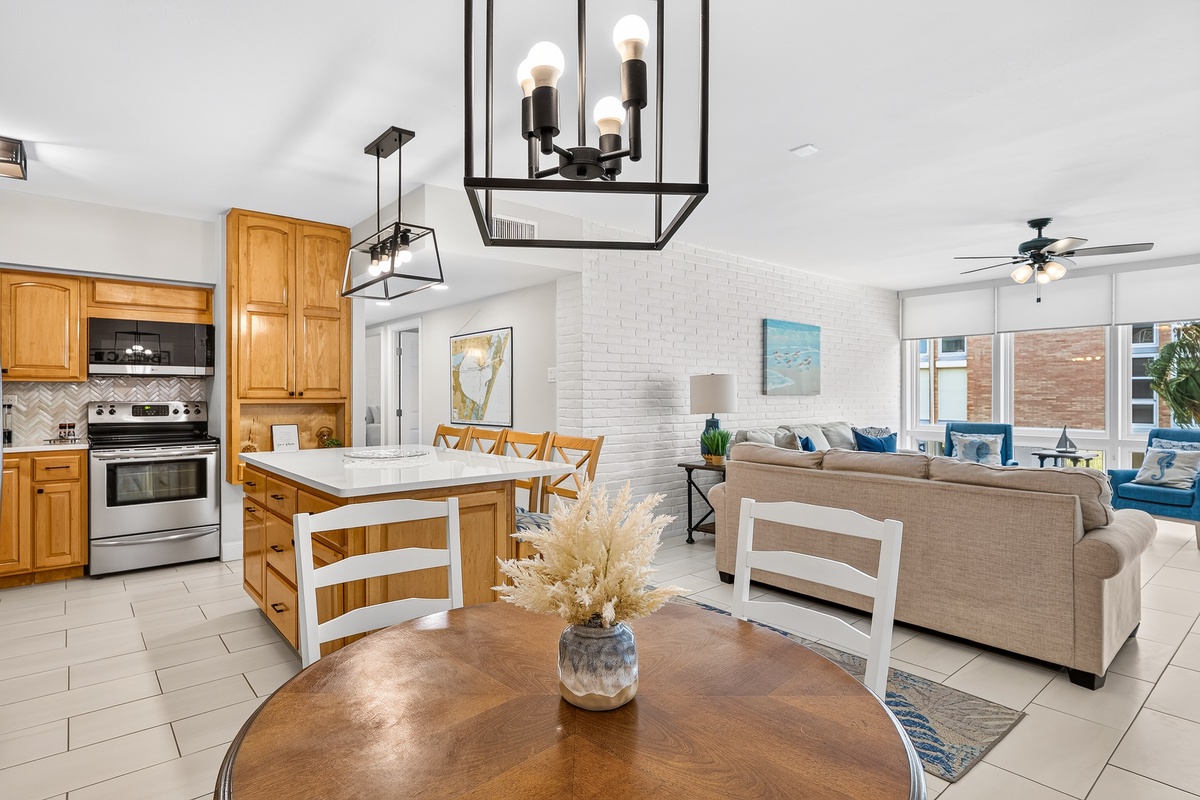 Gather around the inviting open-plan kitchen and living area, where warm wood tones meet coastal charm. You'll love the spacious island for meal prep and the cozy seating that invites relaxed evenings.