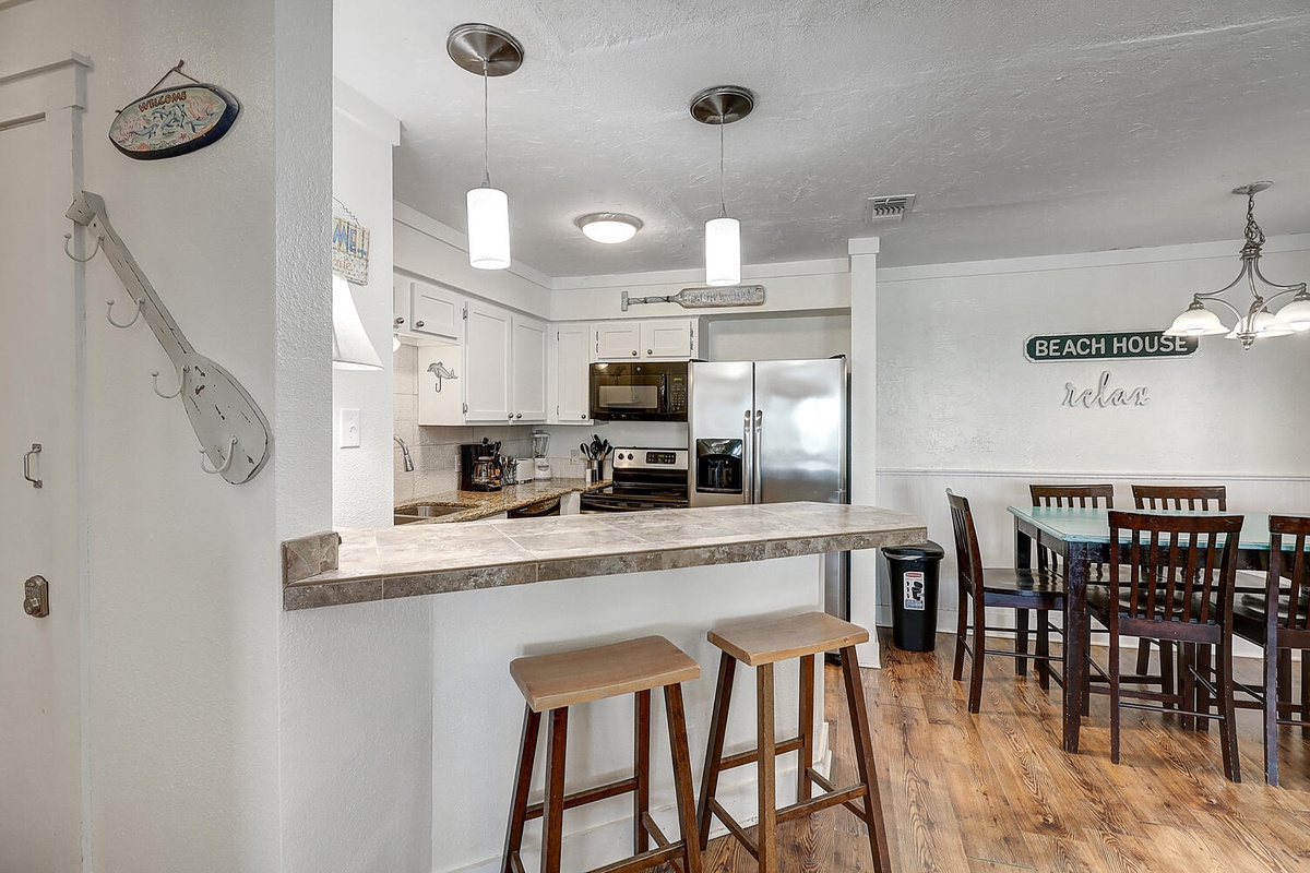 Your open kitchen and dining space invites coastal cooking with granite counters, stainless appliances, and charming beach house touches throughout.