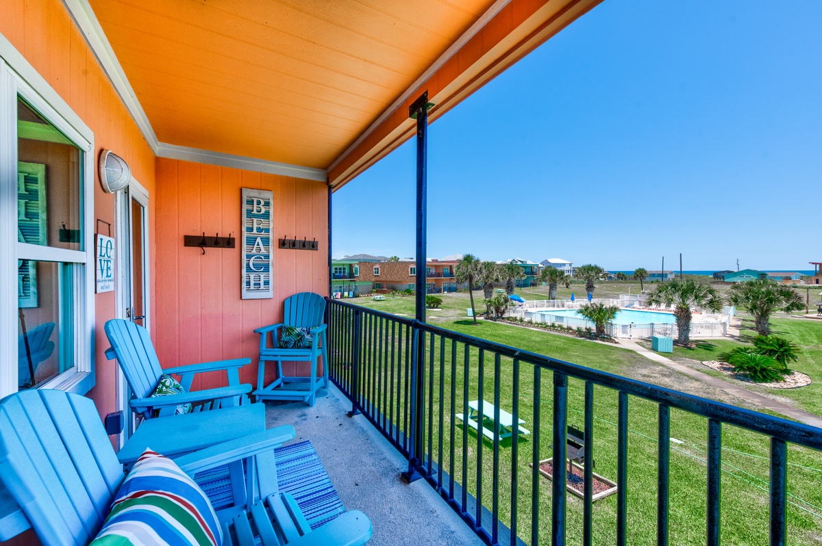 Relax on your private balcony with vibrant blue Adirondack chairs overlooking tropical gardens and the sparkling Gulf waters beyond.