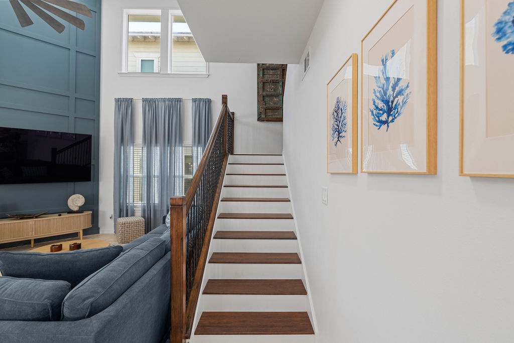 Step into your bright, airy living space where coastal artwork and comfortable furnishings create the perfect retreat for relaxation.