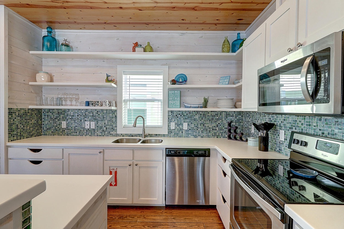 Your fully equipped kitchen features stunning coastal-inspired tiles and modern appliances for preparing delicious meals during your stay.