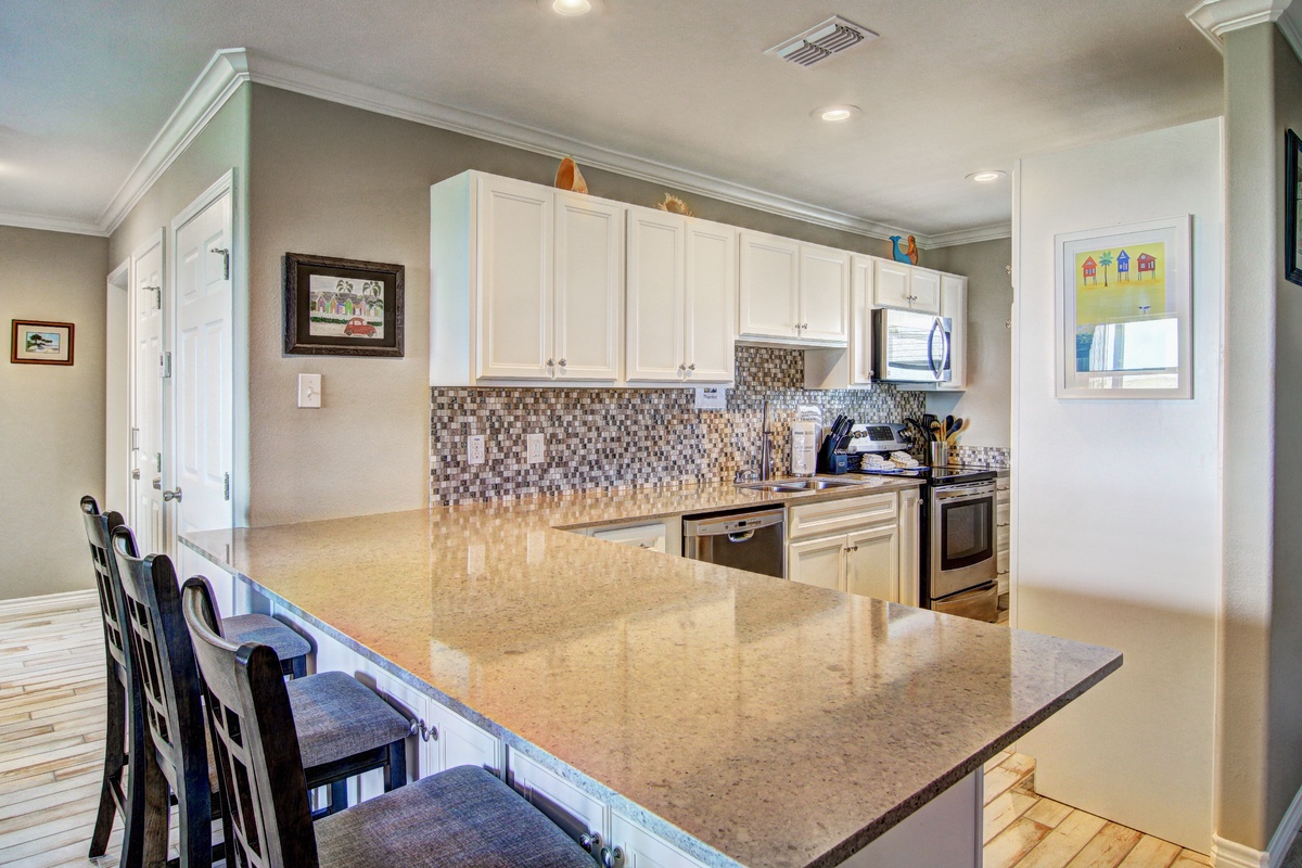 Your spacious kitchen features gleaming granite countertops, modern appliances, and a breakfast bar perfect for morning coffee or casual meals.