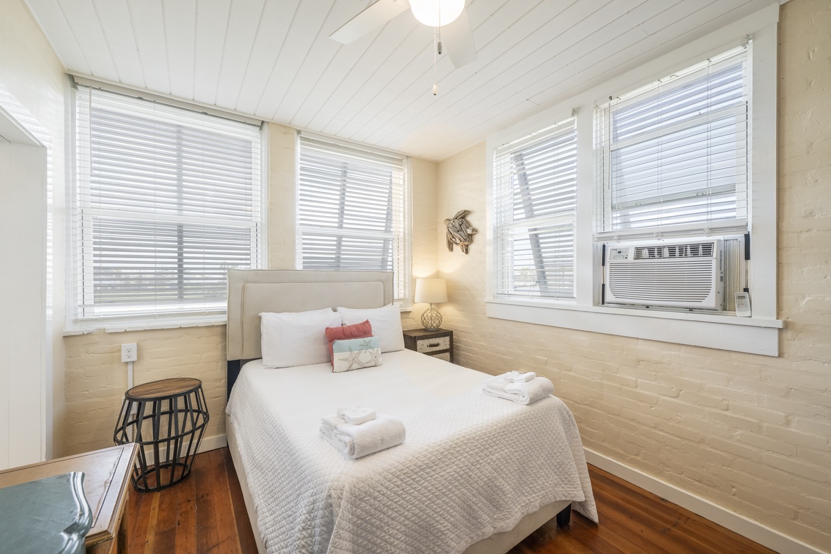 Unwind in your spacious bedroom where natural light streams through windows and a ceiling fan keeps you comfortable. (Upgraded to a queen bed, new photos coming soon)