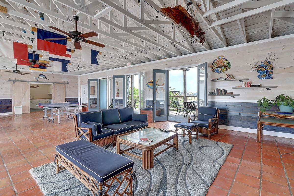 Relax in your spacious nautical-themed living room with exposed beams, bamboo furniture, and coastal views from the patio.