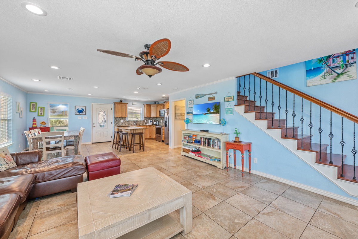 Your spacious open-concept living area flows seamlessly from kitchen to dining, with coastal charm and comfortable seating for family gatherings.