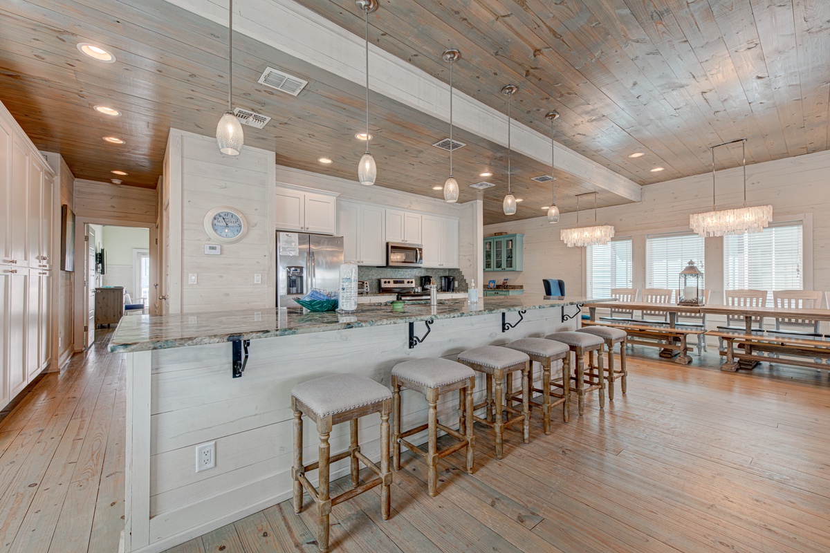 Gather around the spacious kitchen island where coastal charm meets modern convenience for memorable meals together.