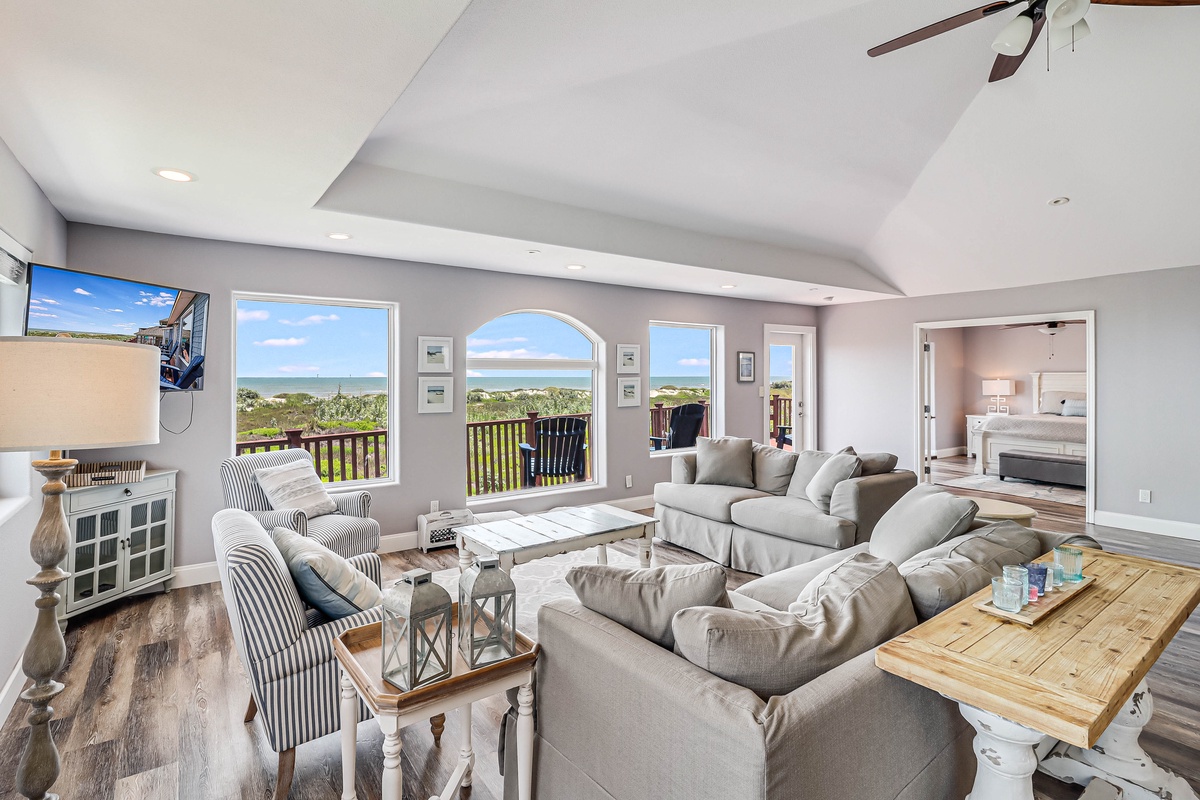 Relax in your bright living room with panoramic ocean views through stunning arched windows. Sink into plush sectional seating as coastal breezes fill the space.