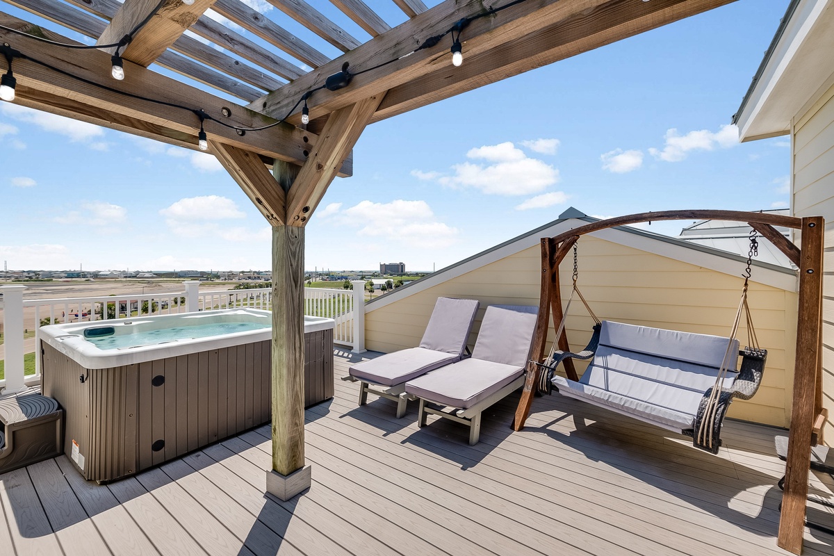Your private rooftop deck with hot tub, lounge chairs, and swing offers the perfect space to unwind under the pergola's shade.