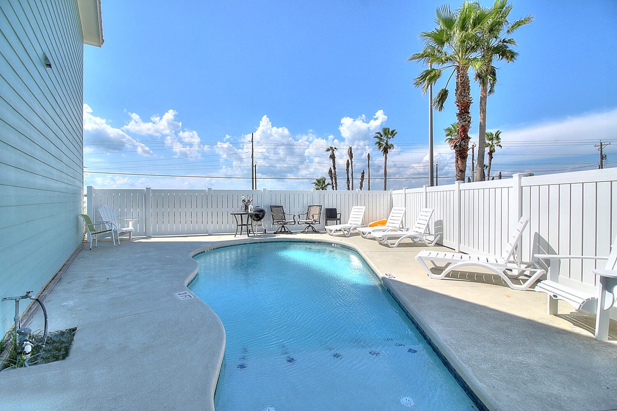 Your private pool oasis awaits with crystal-clear water, comfortable loungers, and swaying palms under endless blue skies.