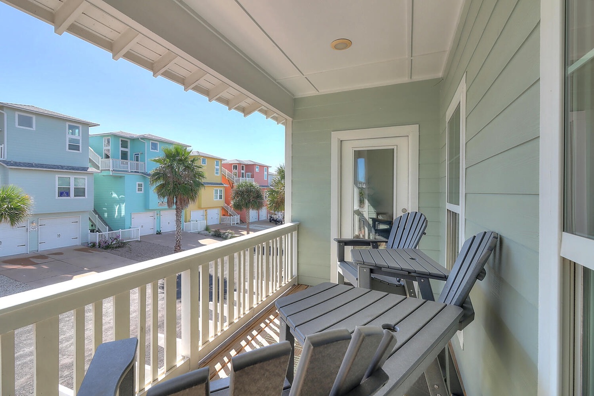Relax on your covered balcony with Adirondack chairs, soaking up colorful neighborhood views and gentle coastal breezes.