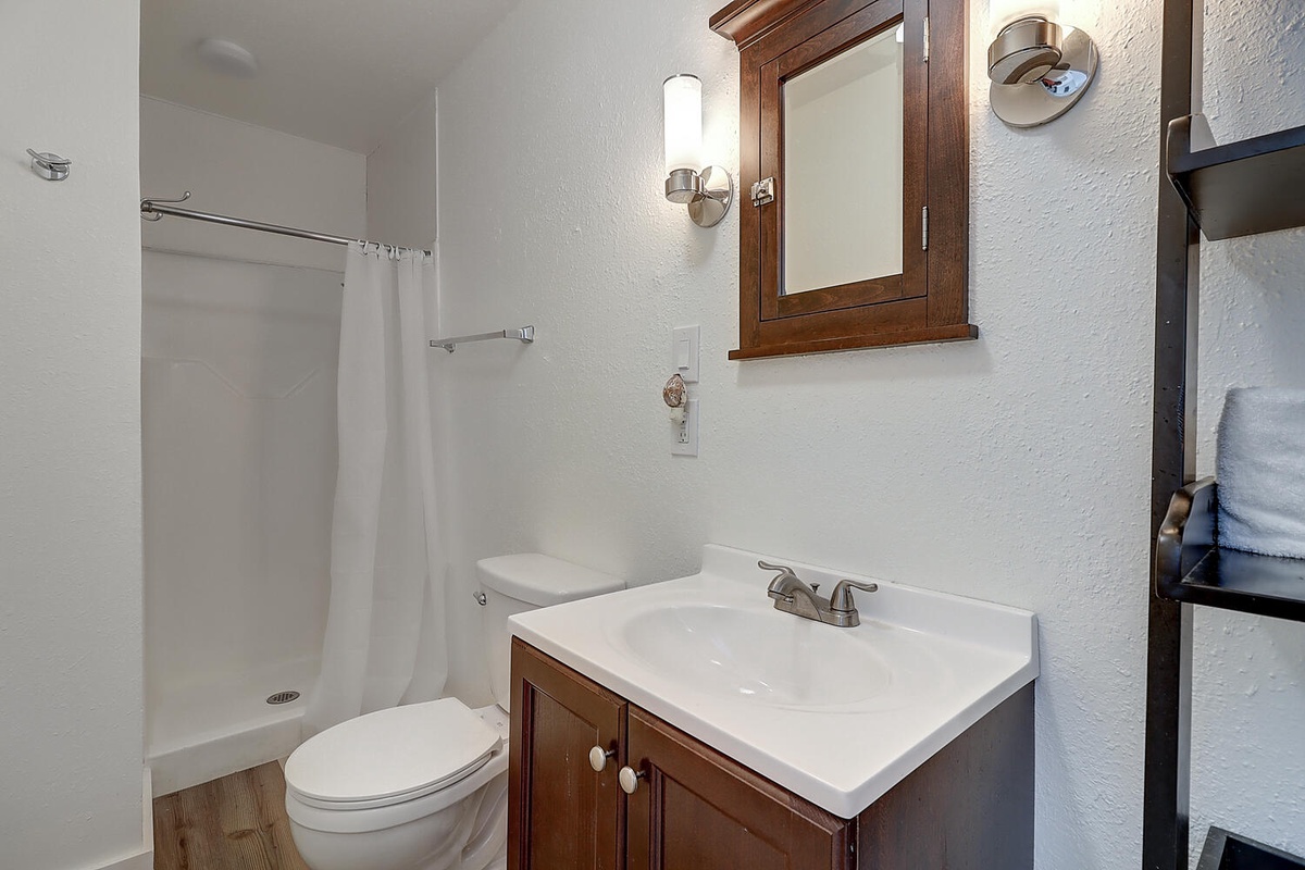 Step into your clean, well-appointed bathroom with warm wood finishes and modern fixtures for your comfort.