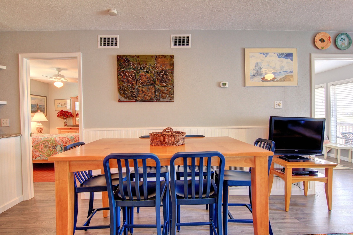 Your bright dining area features a welcoming wood table with cheerful blue chairs, perfect for family meals and conversations.