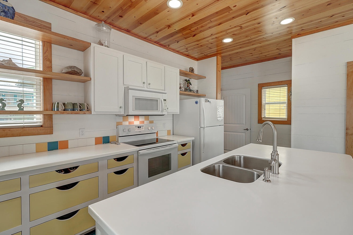 Your bright kitchen awaits with spacious counters, full appliances, and cheerful colors—perfect for preparing meals together.