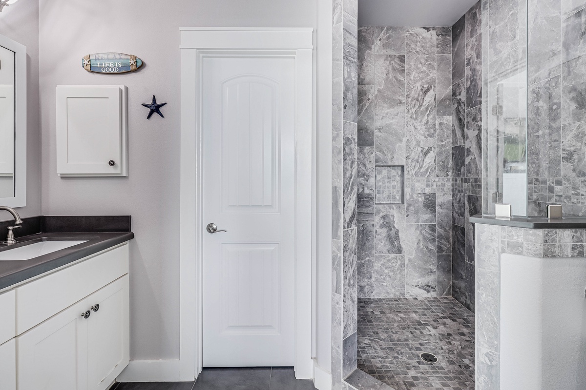 Step into your spa-like retreat with a stunning marble walk-in shower and elegant nautical touches that make every morning feel refreshing.
