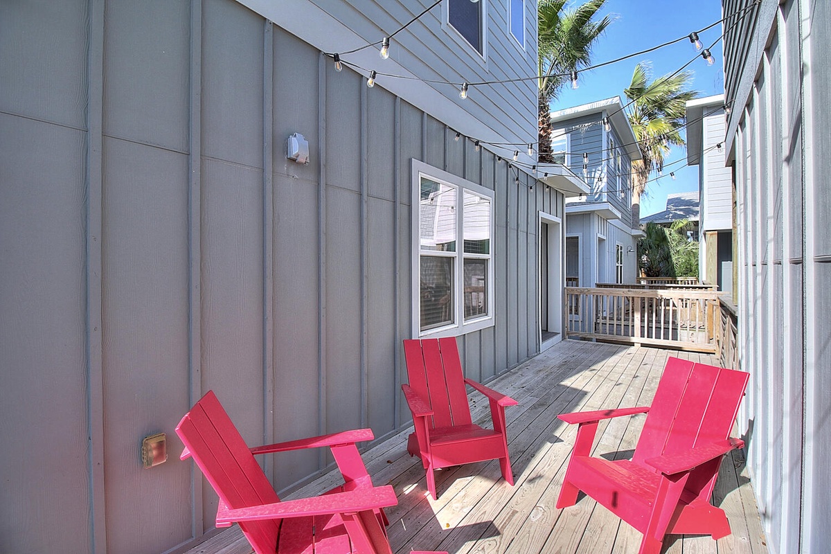 Unwind in bright red Adirondack chairs on your private deck, where string lights create magical evening ambiance.